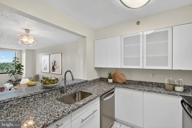 a kitchen with granite countertop a sink a stove and cabinets