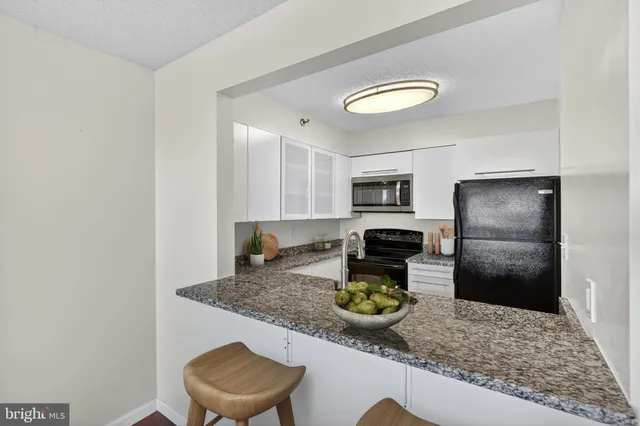 a kitchen with a refrigerator a stove and a sink with wooden floor