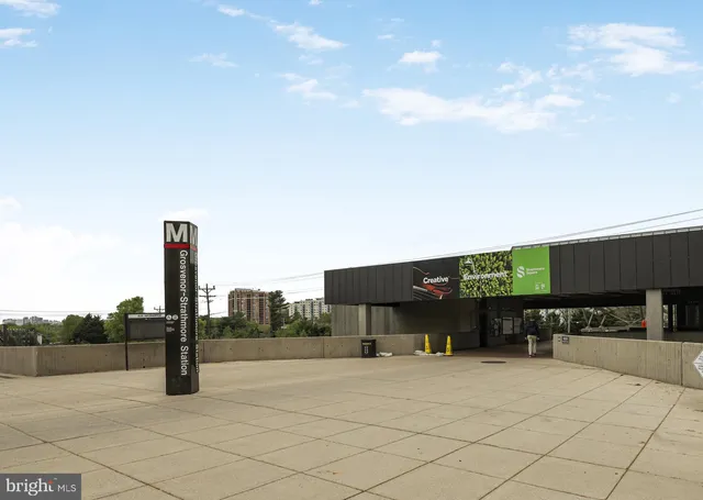 a man walking down a street next to a building