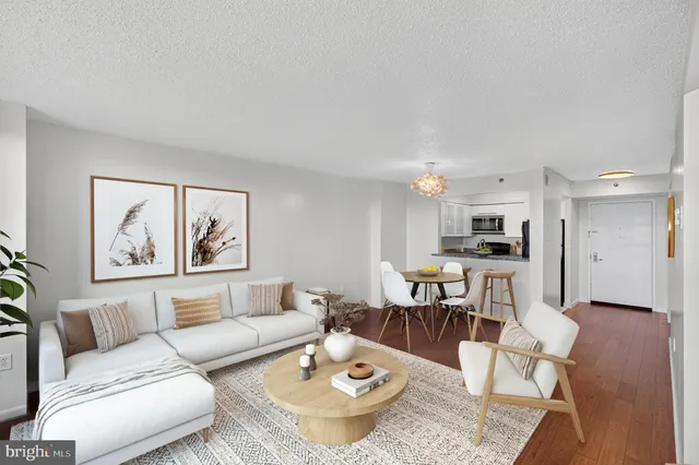a living room with furniture kitchen view and a table