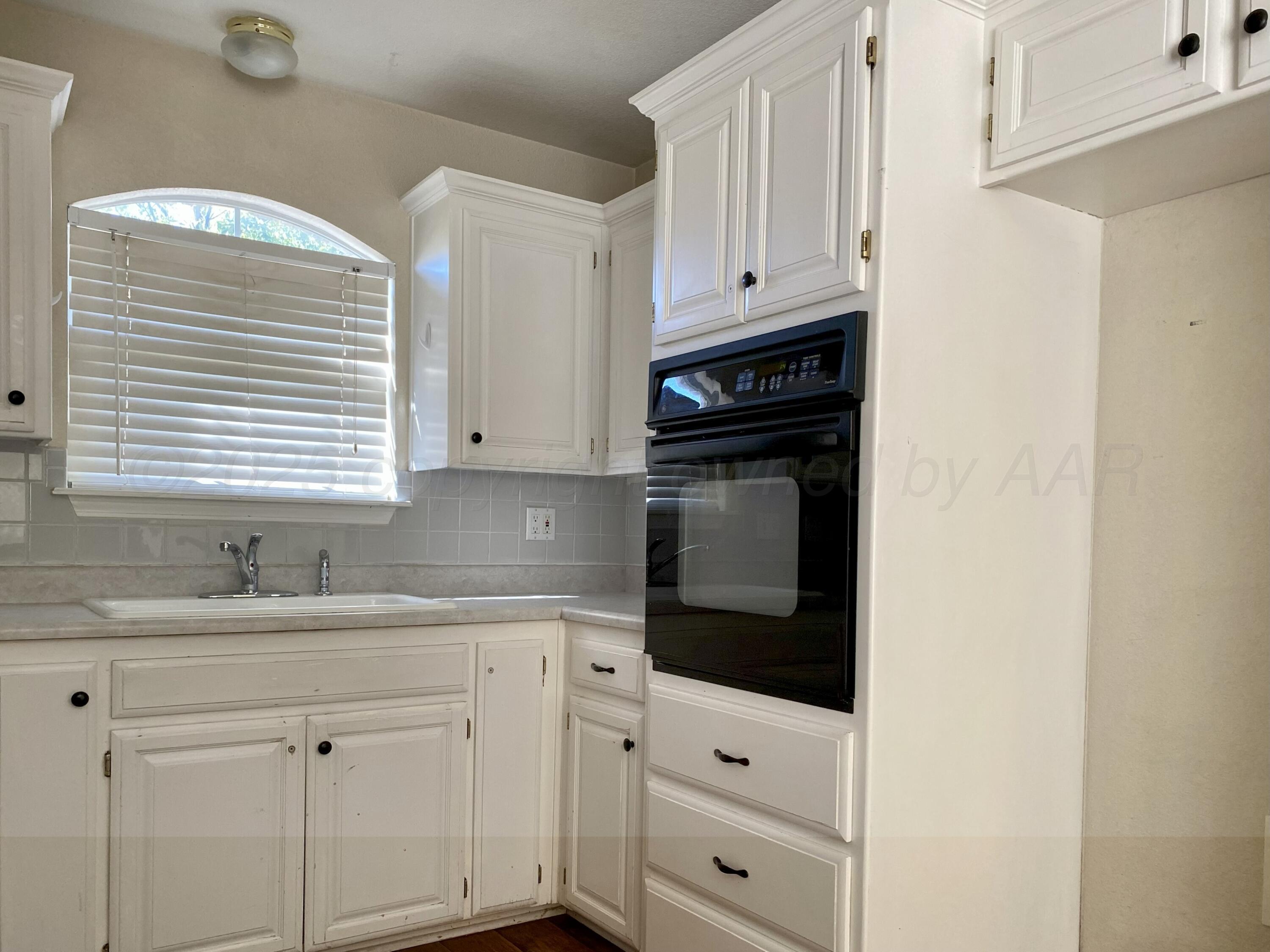 7903 Goal Place Amarillo, TX 79119 - Photo 6 of 14 a kitchen with granite countertop white cabinets and appliances