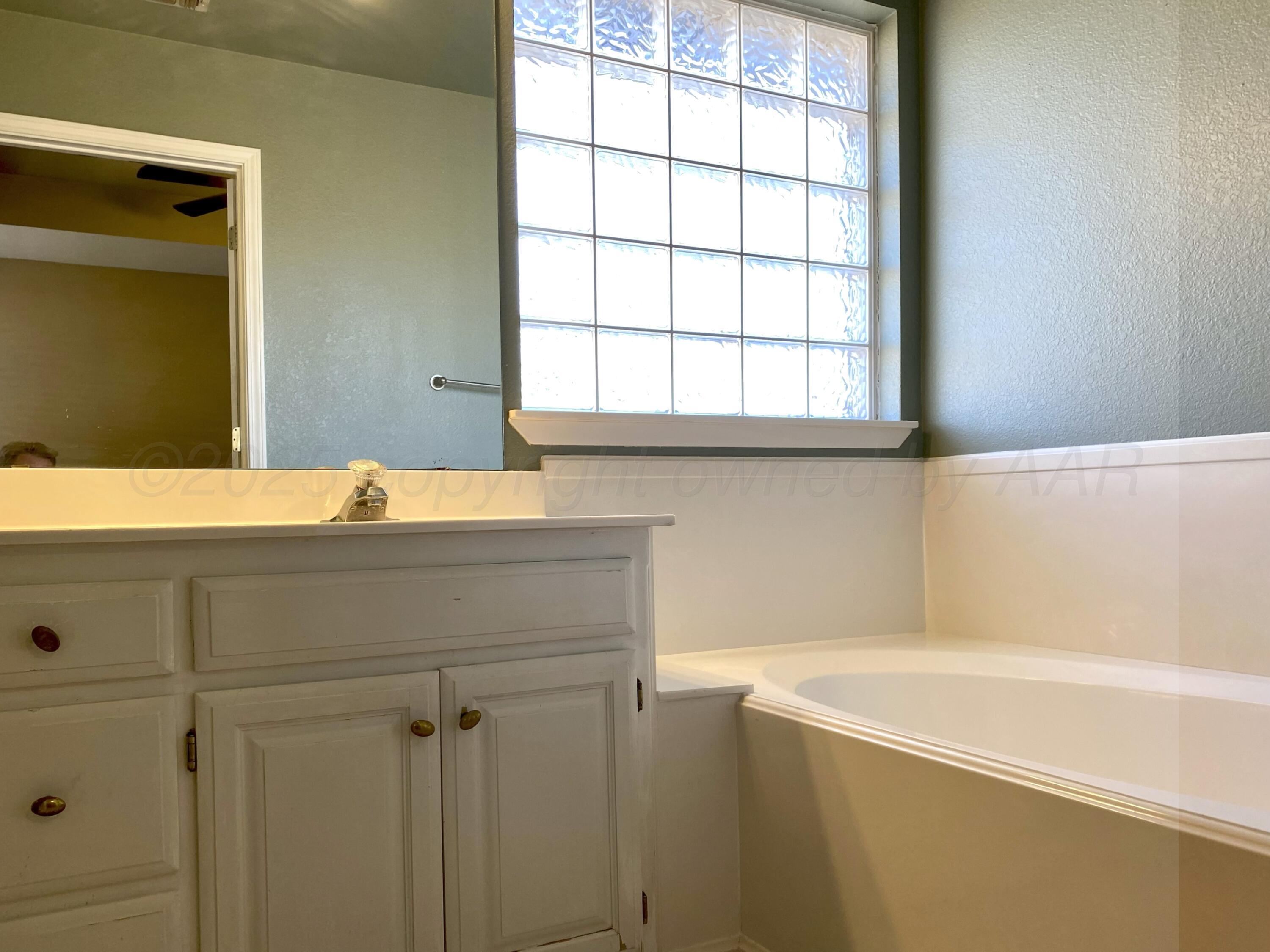 7903 Goal Place Amarillo, TX 79119 - Photo 9 of 14 a bathroom with a bathtub and window