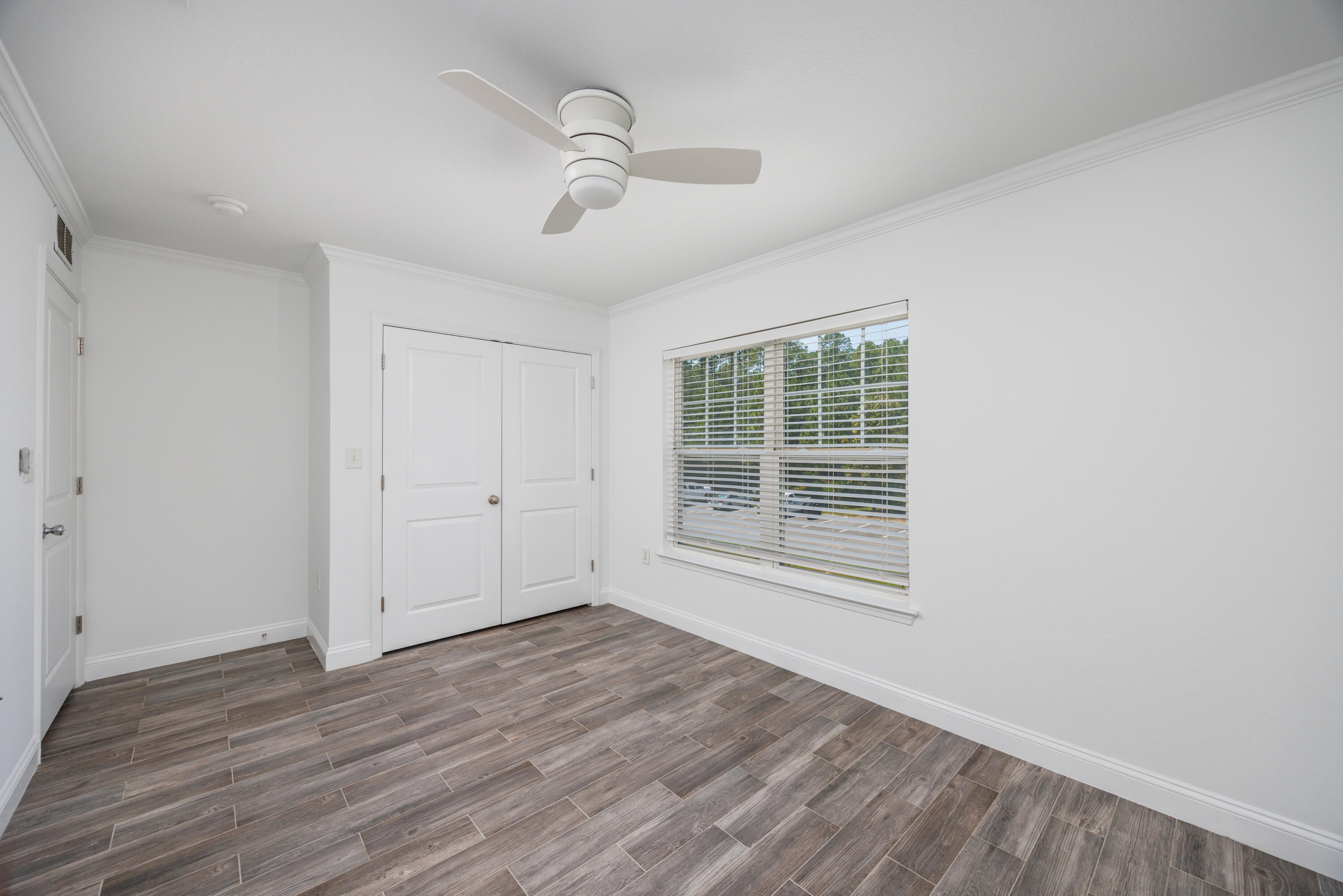 16 South Sand Palm Road Freeport, FL 32439 - Photo 16 of 32 a view of an empty room with wooden floor and a window