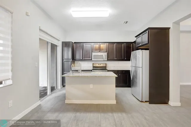 a kitchen with a refrigerator sink and cabinets