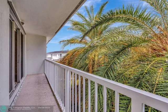 a view of a backyard with a chair and potted plants