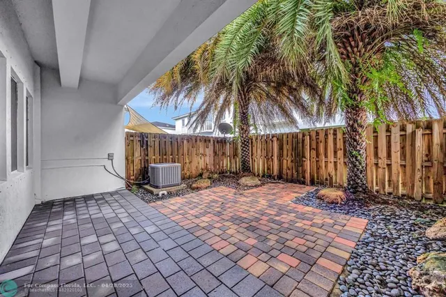a backyard of a house with fountain table and chairs