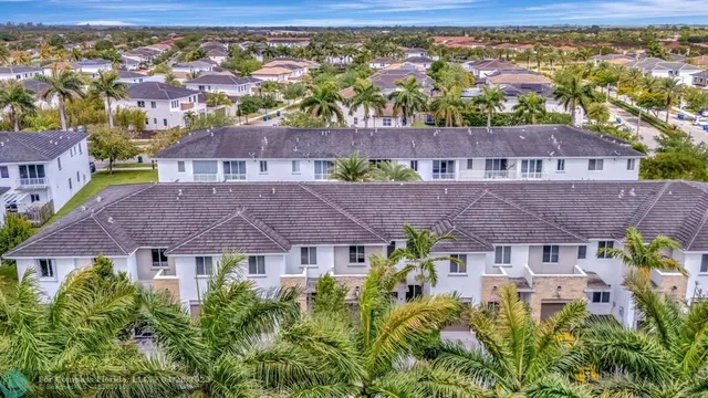 an aerial view of residential houses with outdoor space and street view