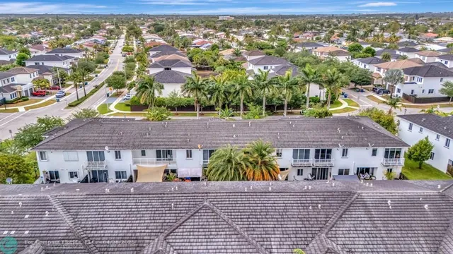 an aerial view of multiple houses with a yard