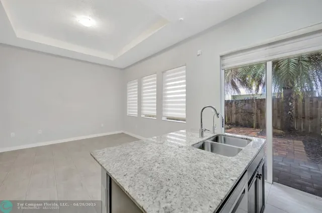 a kitchen with granite countertop a sink and a wooden floor
