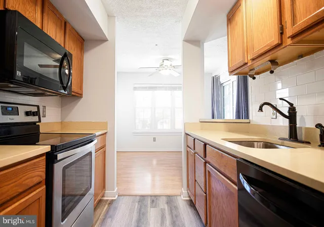 a kitchen with stainless steel appliances granite countertop a sink a stove and a microwave