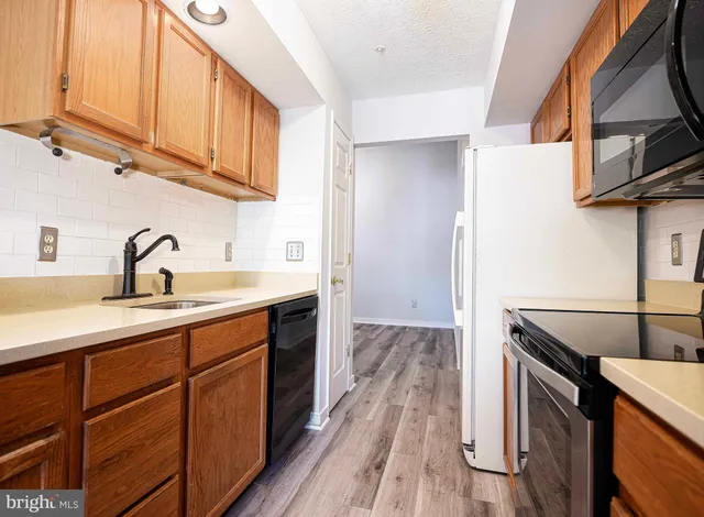 a kitchen with stainless steel appliances granite countertop a sink a stove and a refrigerator