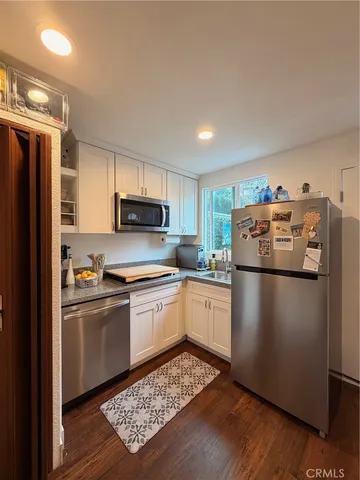 a kitchen with stainless steel appliances granite countertop a refrigerator a stove a sink and a microwave