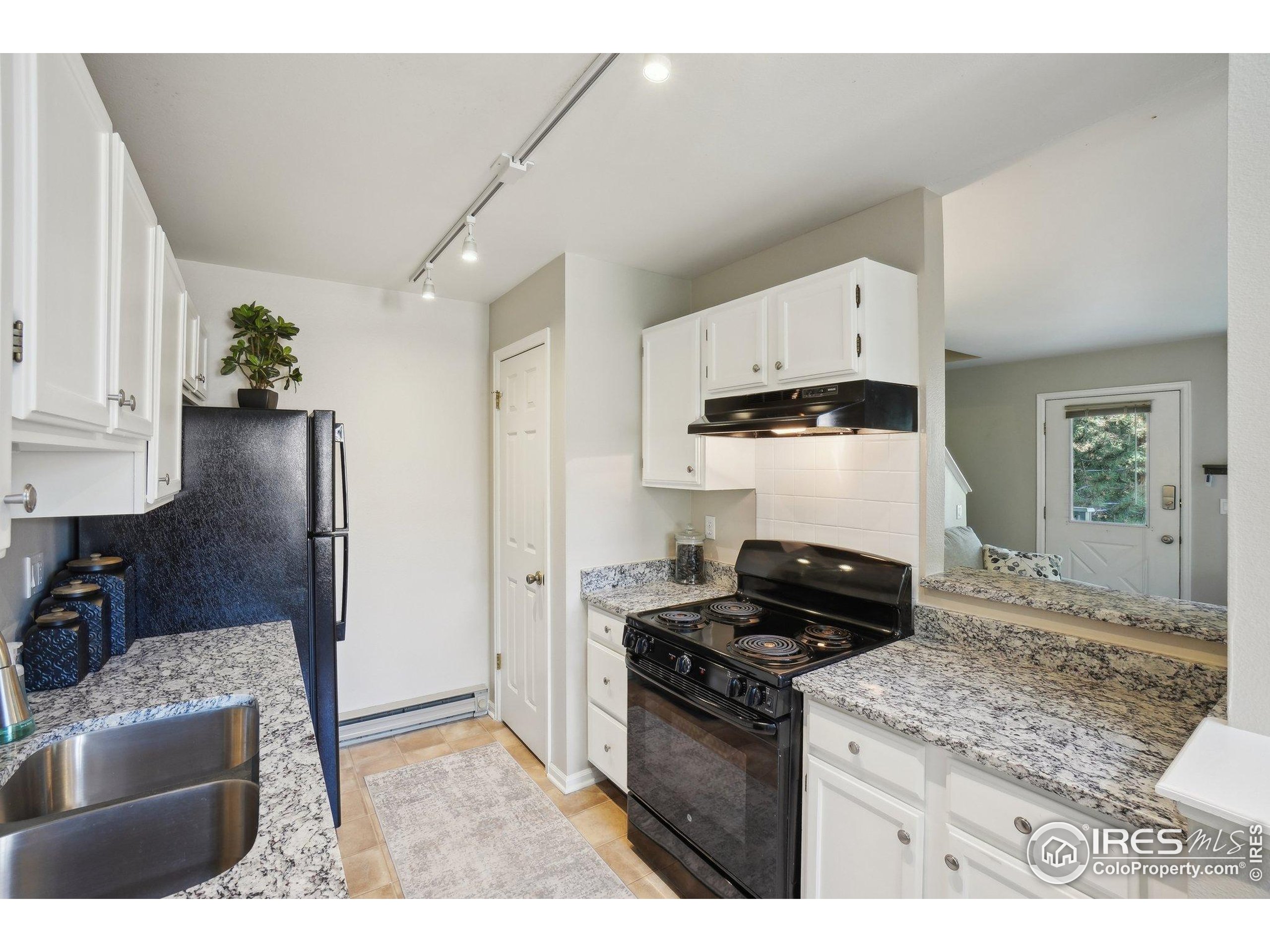 1601 West Swallow Road, Unit 9 Fort Collins, CO 80526 - Photo 13 of 33 a kitchen with granite countertop a stove and a sink