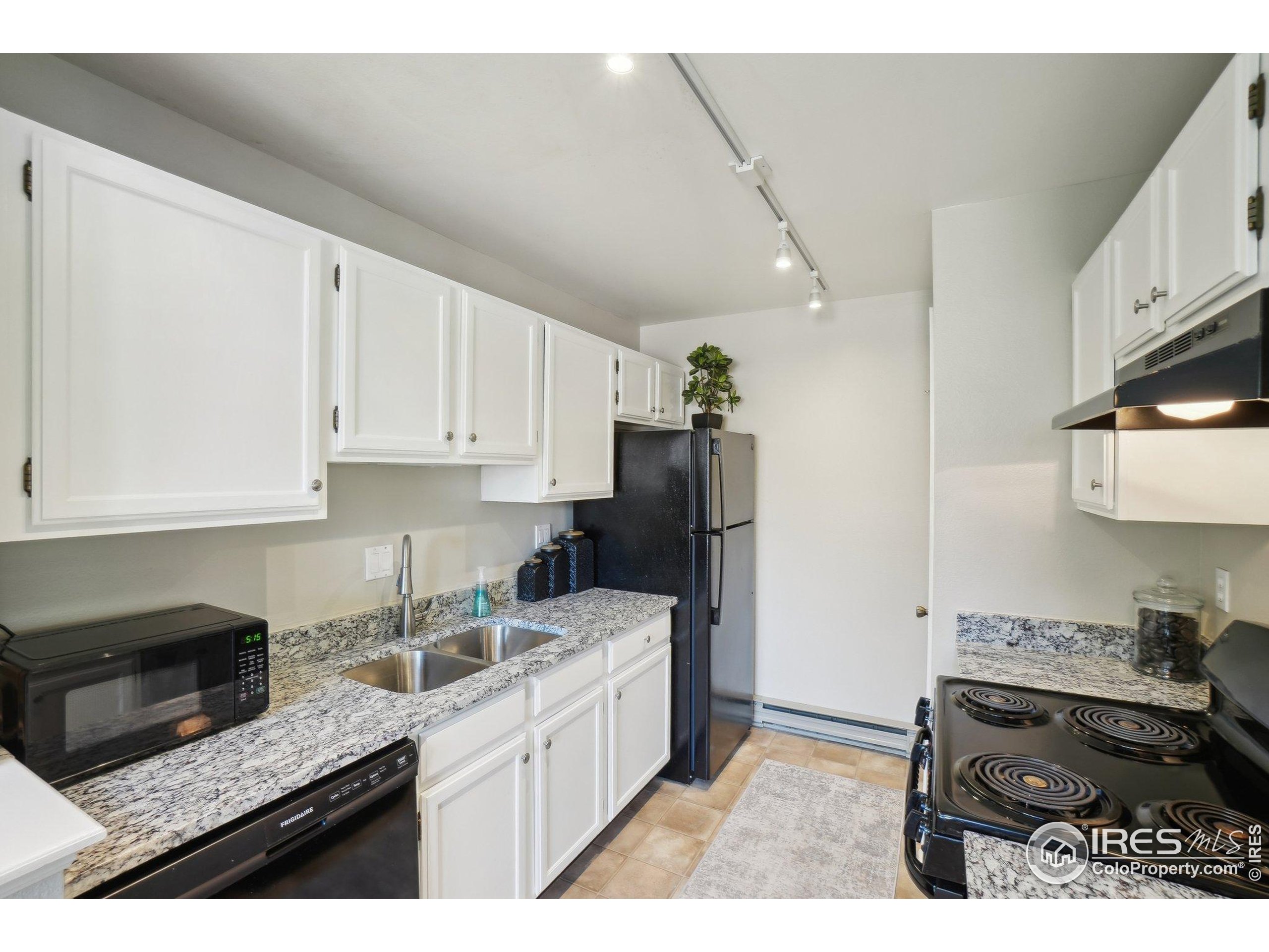 1601 West Swallow Road, Unit 9 Fort Collins, CO 80526 - Photo 15 of 33 a kitchen with stainless steel appliances granite countertop a stove a sink and a refrigerator