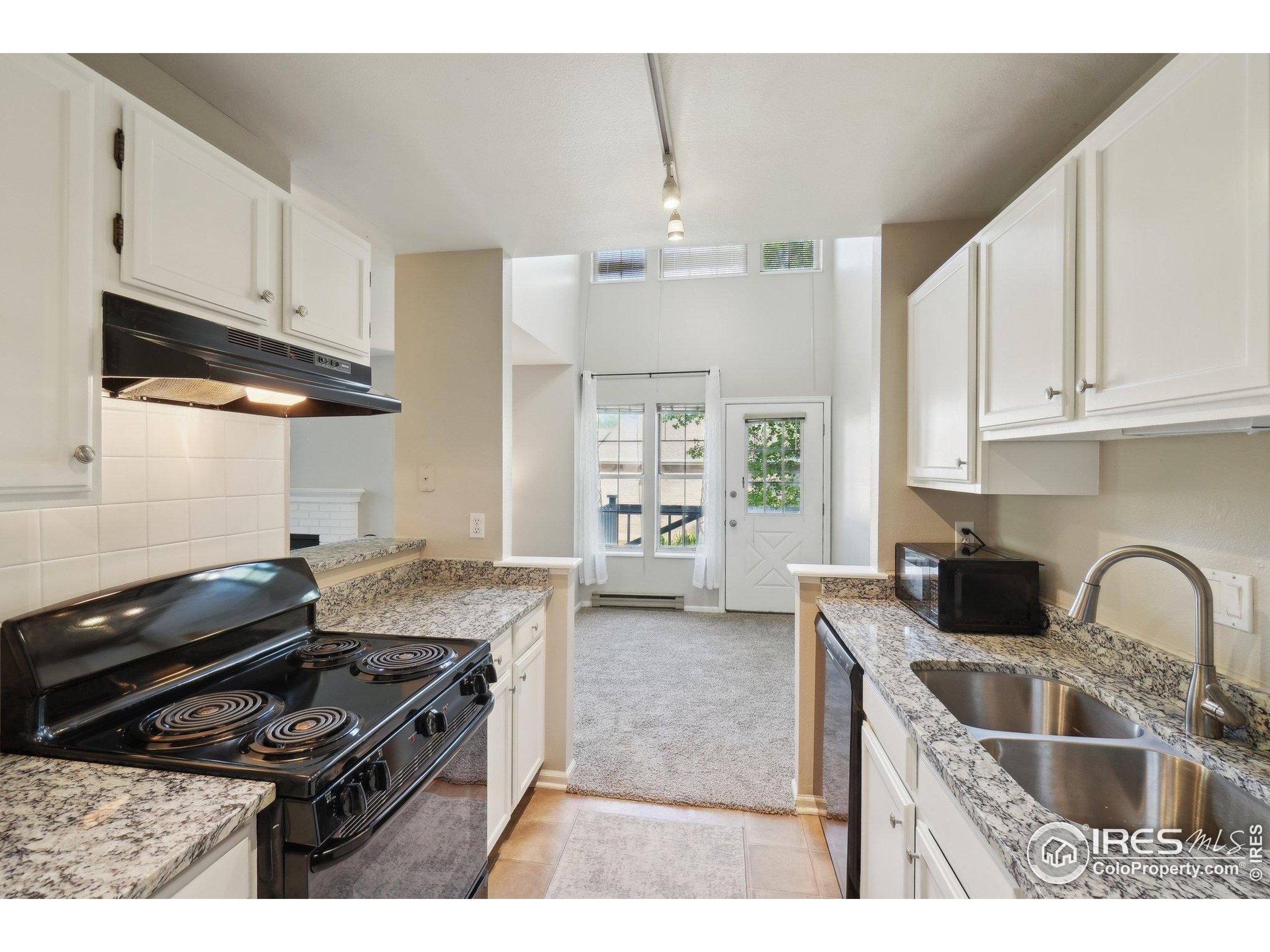 1601 West Swallow Road, Unit 9 Fort Collins, CO 80526 - Photo 18 of 33 a kitchen with granite countertop a stove and a sink