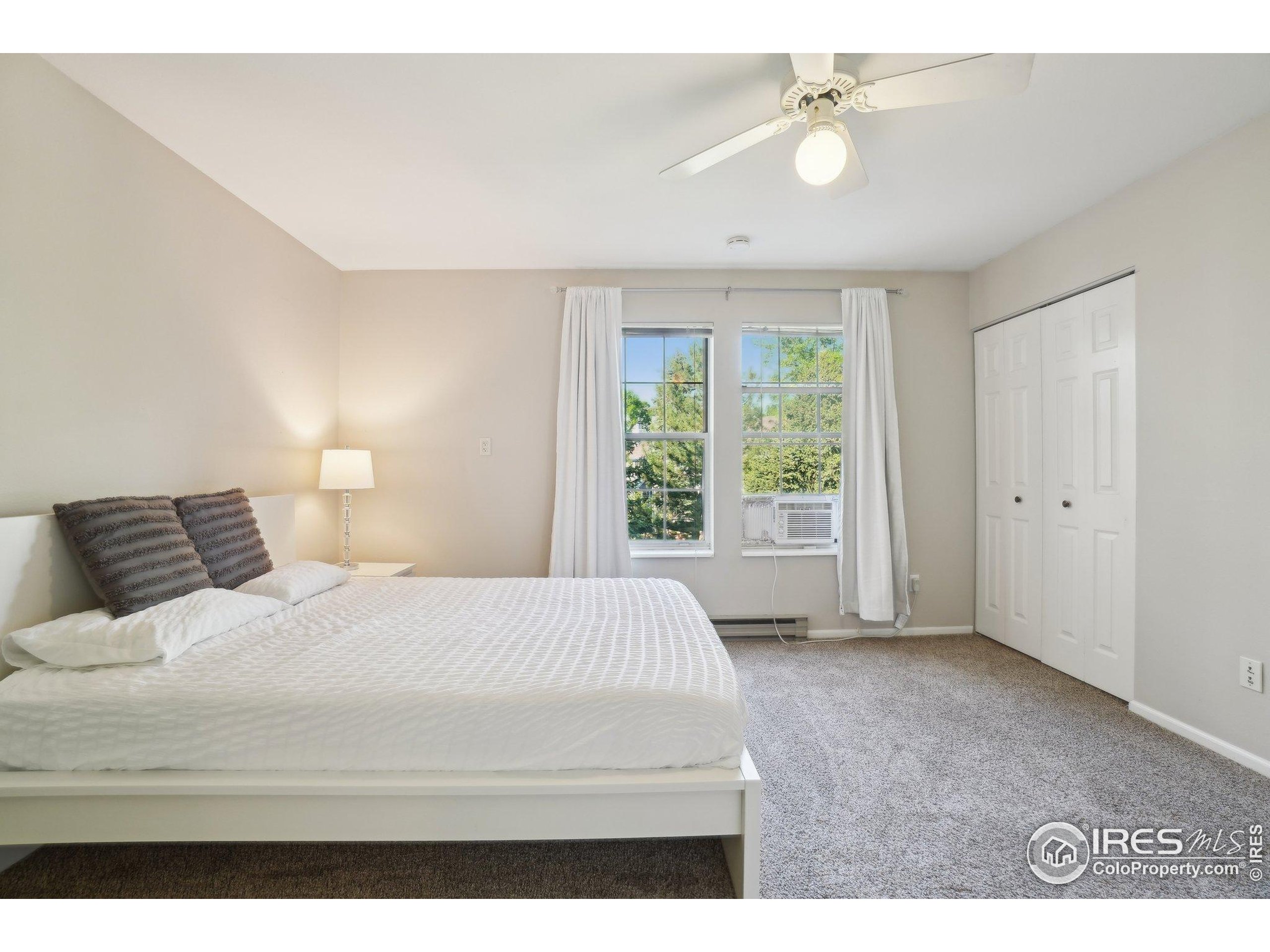 1601 West Swallow Road, Unit 9 Fort Collins, CO 80526 - Photo 23 of 33 a bedroom with a large bed and a chandelier