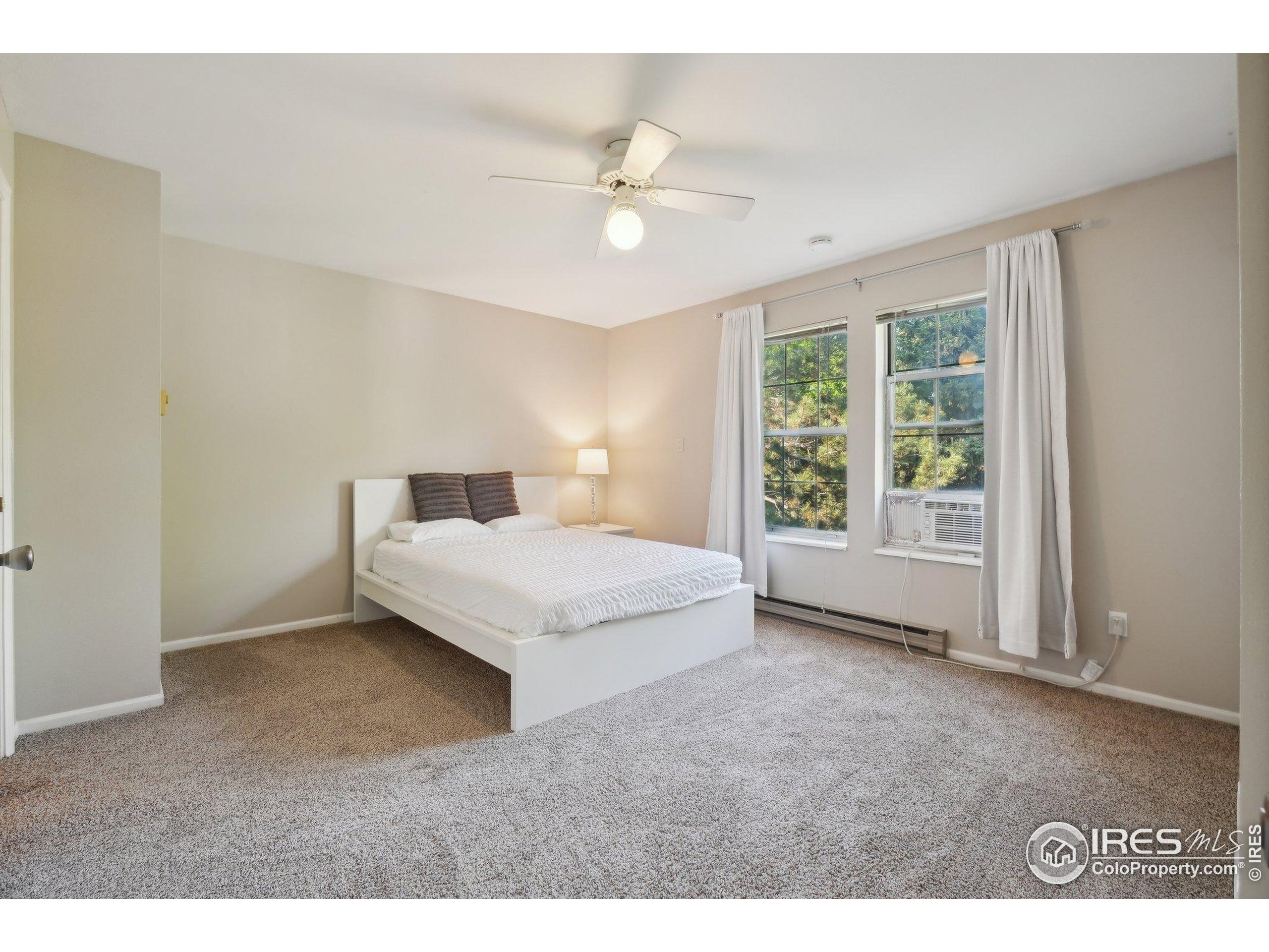 1601 West Swallow Road, Unit 9 Fort Collins, CO 80526 - Photo 24 of 33 a spacious bedroom with a large bed and a chandelier