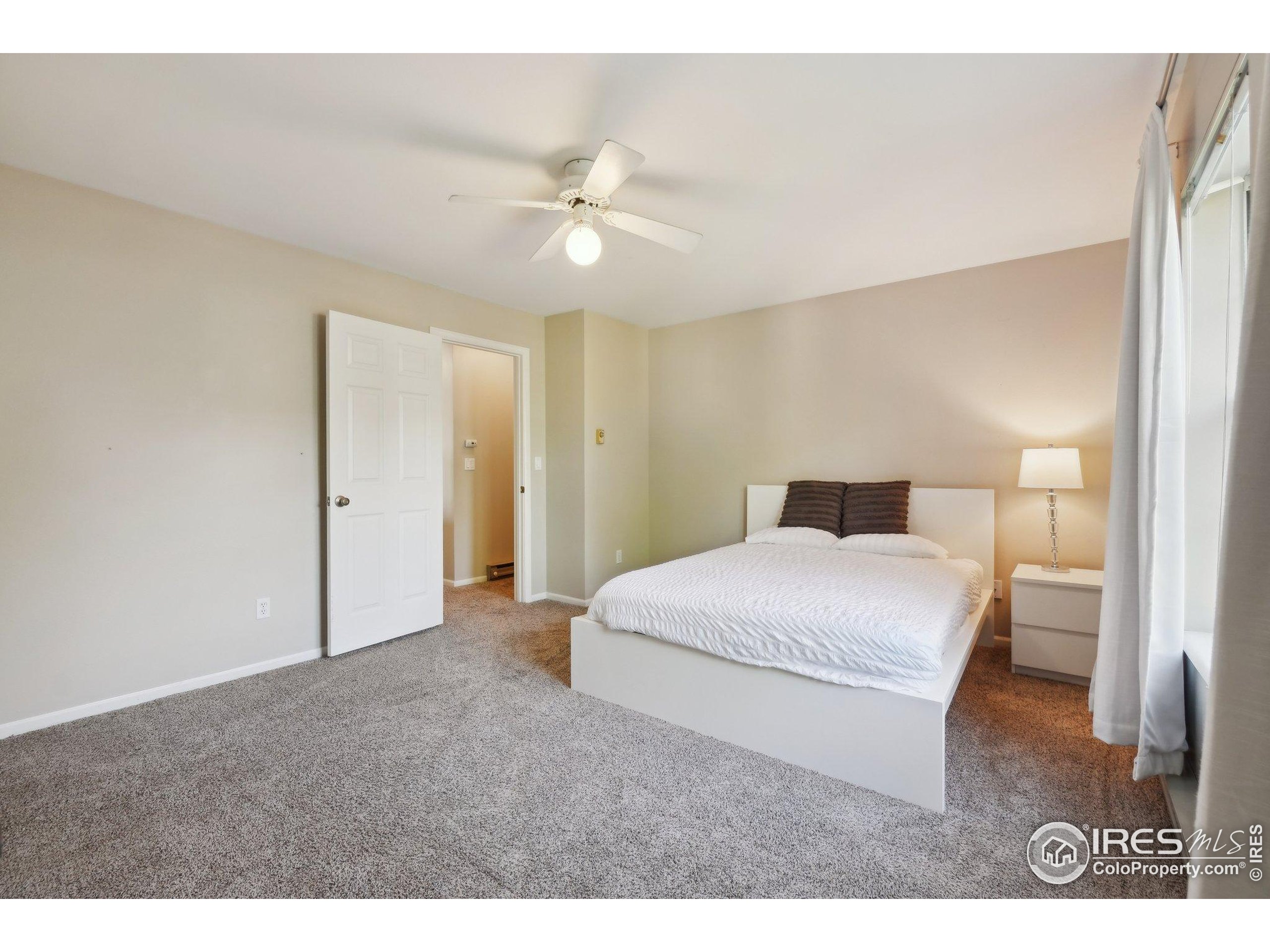 1601 West Swallow Road, Unit 9 Fort Collins, CO 80526 - Photo 25 of 33 a bedroom with a large bed and a chandelier