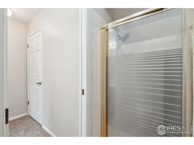 a view of an empty room with wooden floor and fence