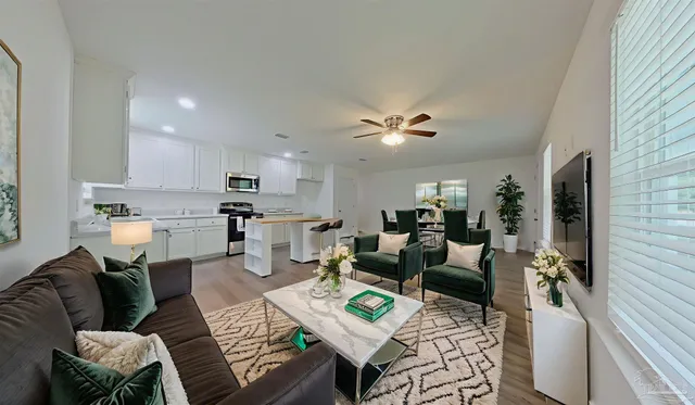 a living room with furniture kitchen view and a window