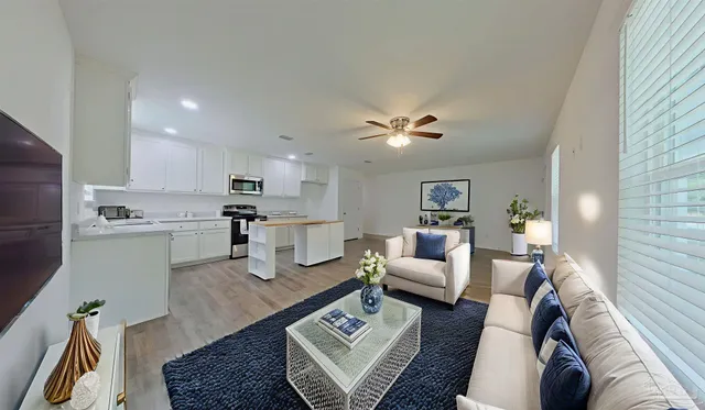 a living room with furniture and kitchen view