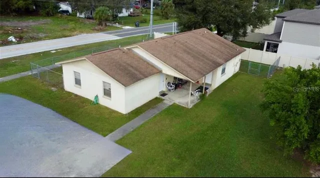 a aerial view of a house with a yard table and chairs
