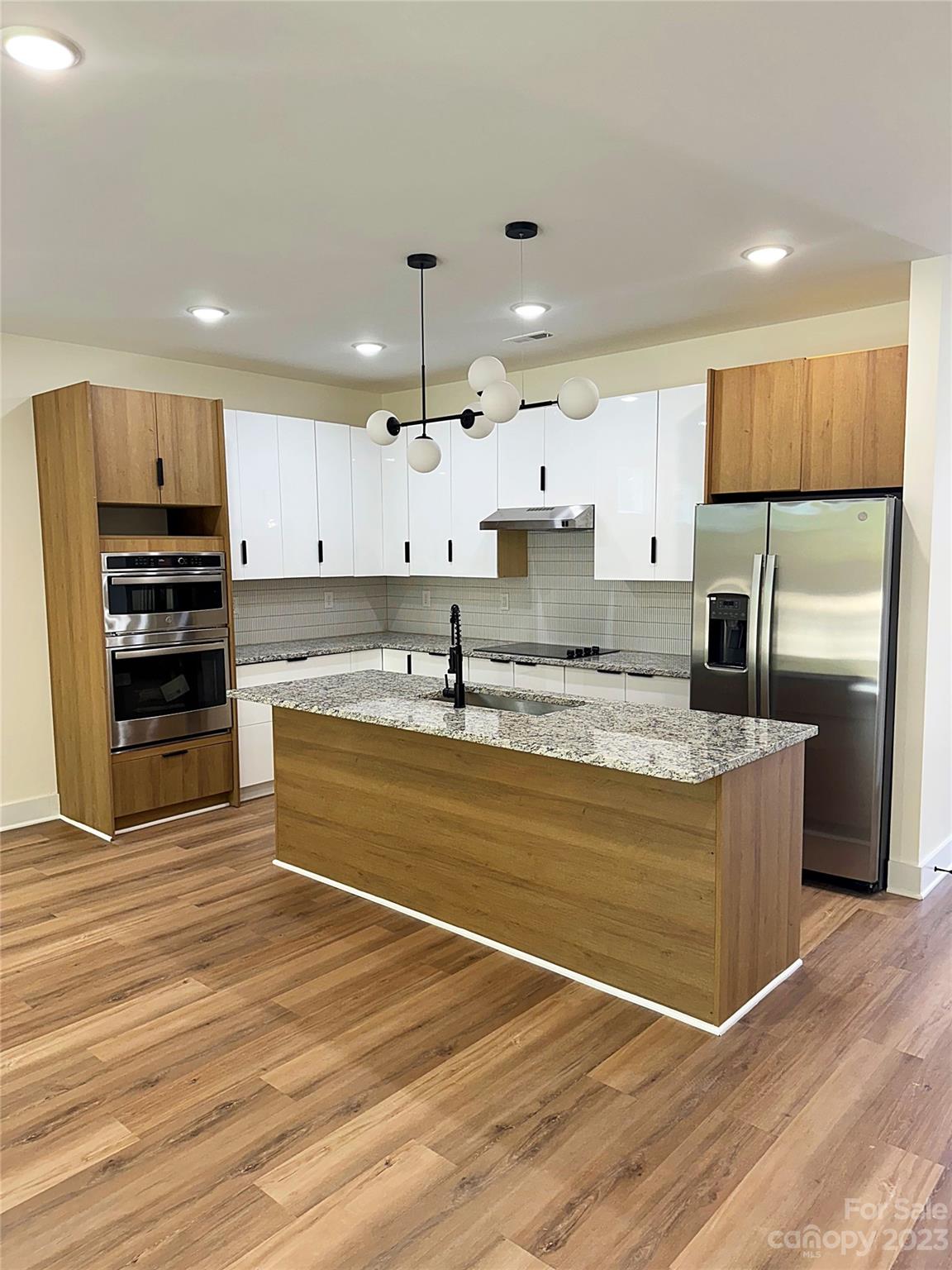 2208 Moose Road Kannapolis, NC 28083 - Photo 2 of 8 a large kitchen with stainless steel appliances kitchen island granite countertop a refrigerator a stove a sink and white cabinets with wooden floor