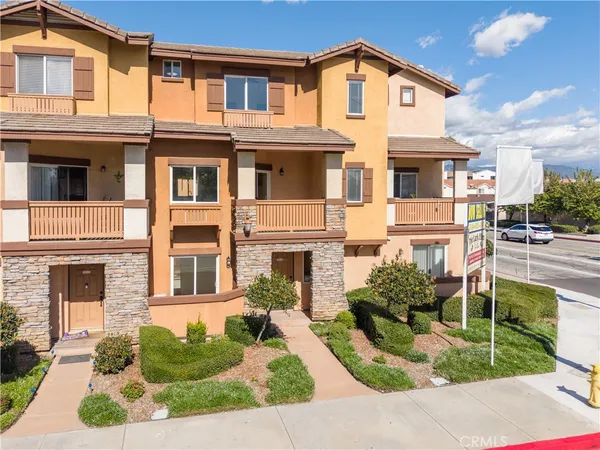 a front view of a multi story residential apartment building with a yard