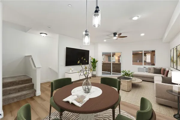 a living room with furniture kitchen view and a flat screen tv