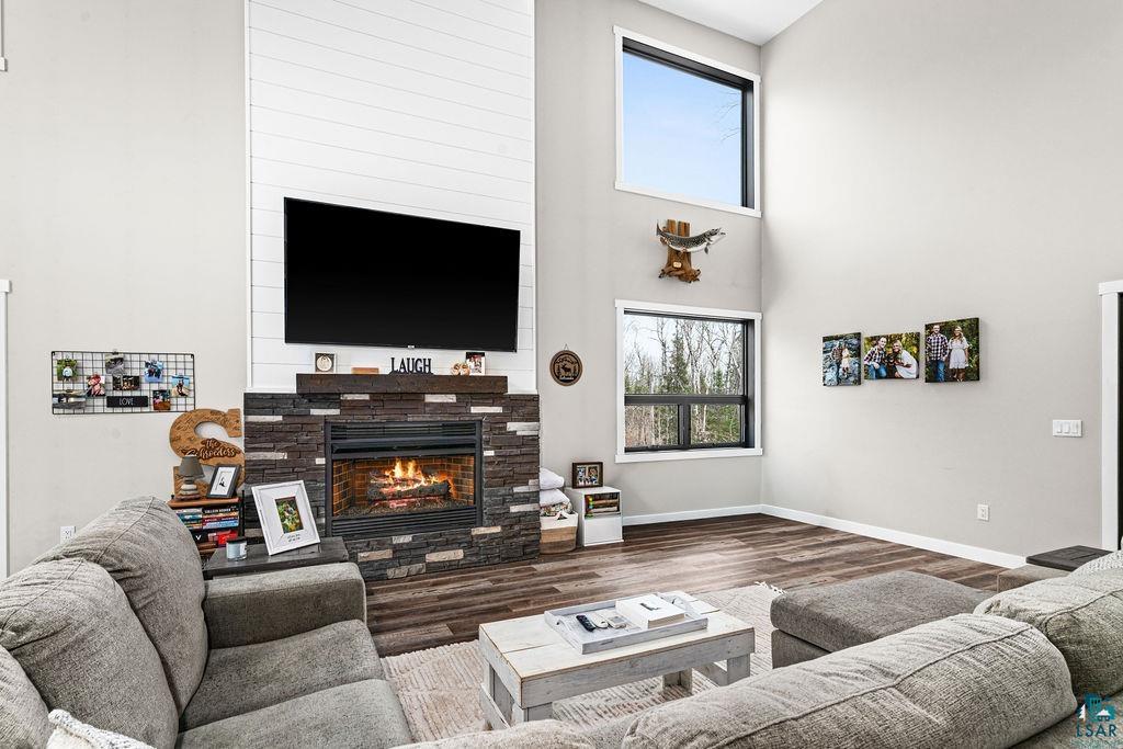 5174 Upper Peterson Road Duluth, MN 55804 - Photo 10 of 42 Living area with a high ceiling, a glass covered fireplace, and wood finished floors