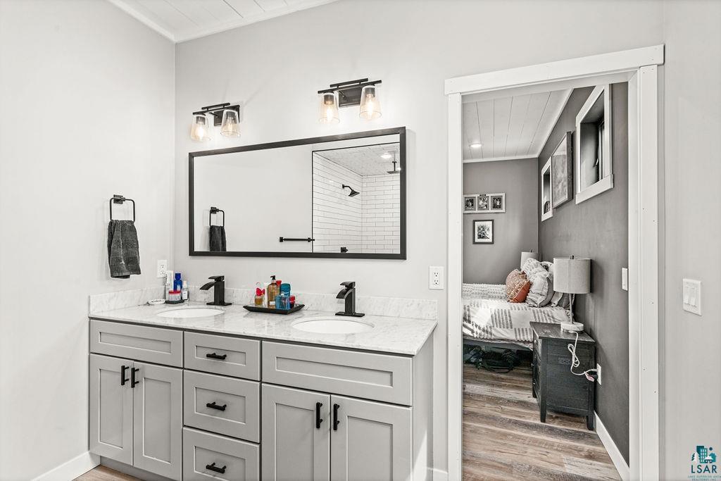 5174 Upper Peterson Road Duluth, MN 55804 - Photo 17 of 42 Full bathroom with double vanity, light wood-style flooring, ensuite bathroom, a shower, and wood ceiling