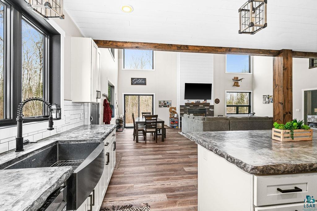 5174 Upper Peterson Road Duluth, MN 55804 - Photo 42 of 42 Kitchen featuring open floor plan, white cabinetry, dark countertops, dark wood-type flooring, and decorative backsplash