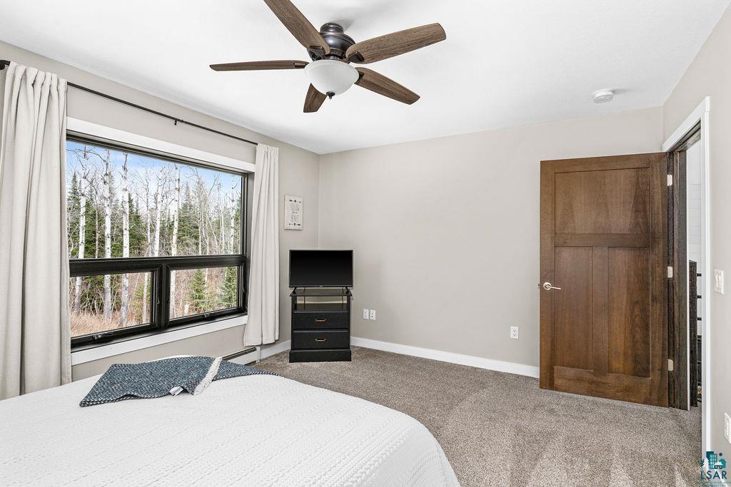 5174 Upper Peterson Road Duluth, MN 55804 - Photo 24 of 42 Bedroom featuring light colored carpet, a ceiling fan, and a baseboard radiator