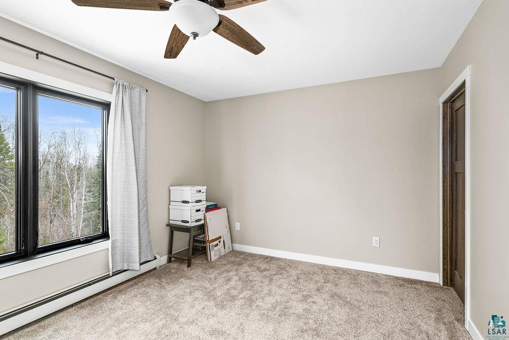 5174 Upper Peterson Road Duluth, MN 55804 - Photo 38 of 42 Unfurnished room with a baseboard radiator, a ceiling fan, and light colored carpet