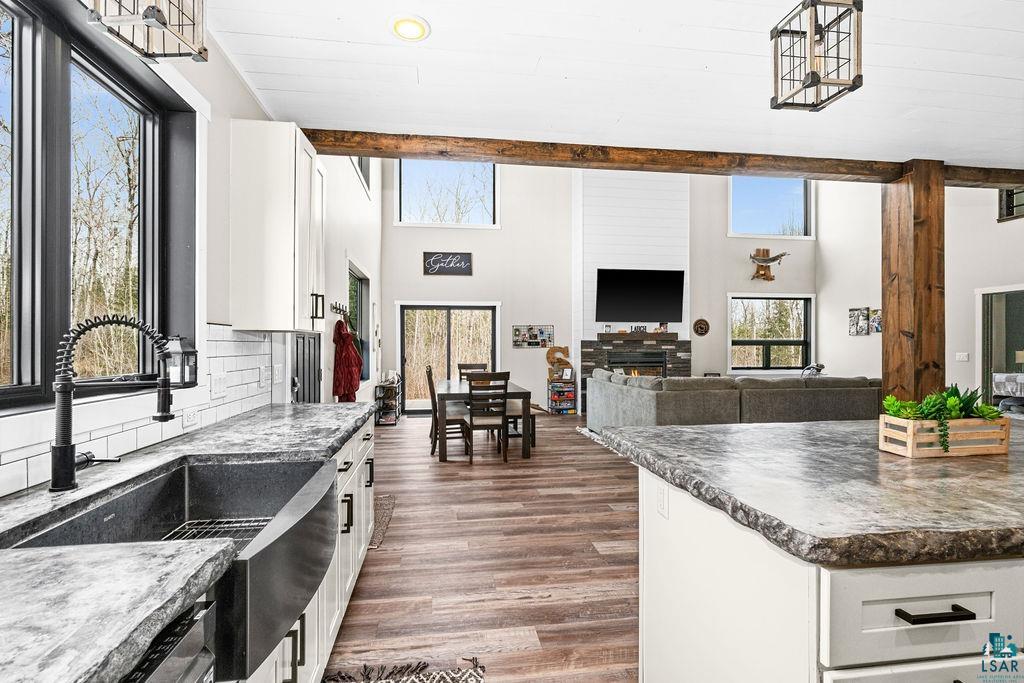 5174 Upper Peterson Road Duluth, MN 55804 - Photo 41 of 42 Kitchen with open floor plan, white cabinets, dark countertops, dark wood-style floors, and tasteful backsplash