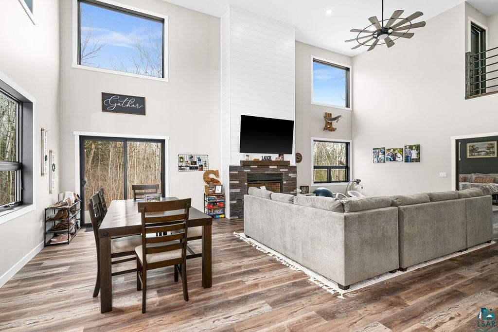 5174 Upper Peterson Road Duluth, MN 55804 - Photo 6 of 42 Living room featuring a high ceiling, wood finished floors, a ceiling fan, and a fireplace