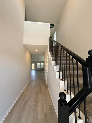 a view of a hallway with wooden floor and staircase