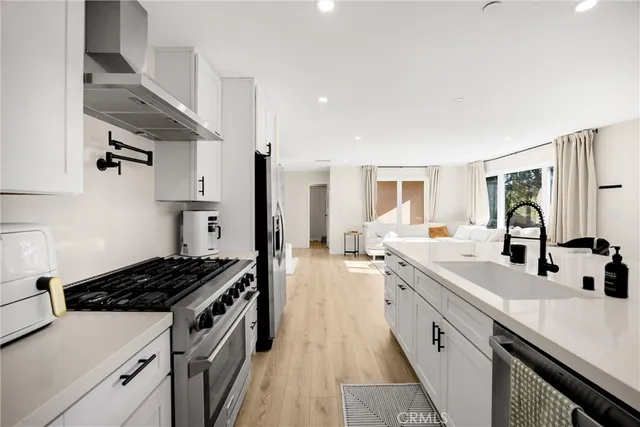 a kitchen with a sink stove top oven and cabinets
