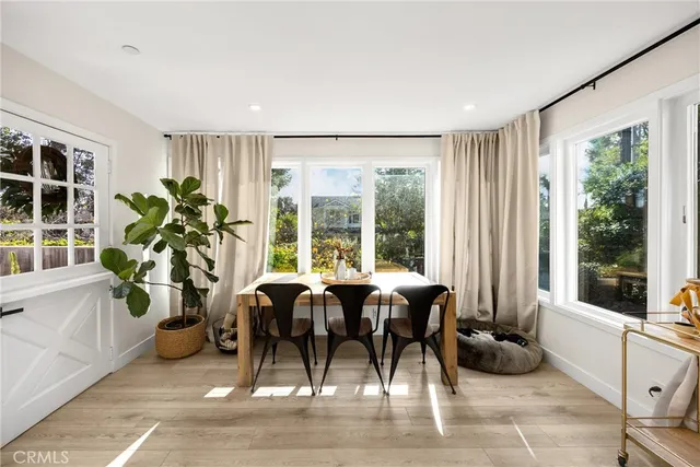 a dining room with furniture and large windows