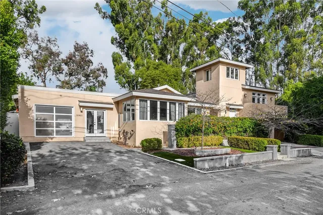 a view of house with a yard and large trees