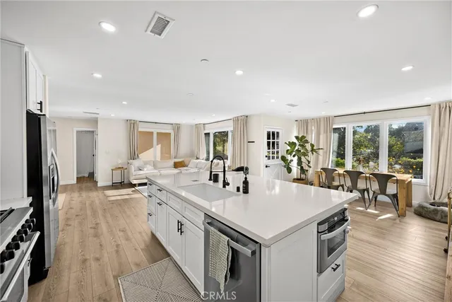 a large white kitchen with sink and cabinets