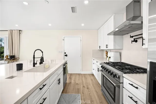 a kitchen with stainless steel appliances granite countertop a sink stove and cabinets