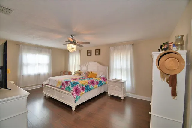 a view of a patio with table and chairs under an umbrella with large trees