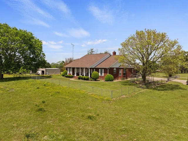 a front view of a house with a big yard