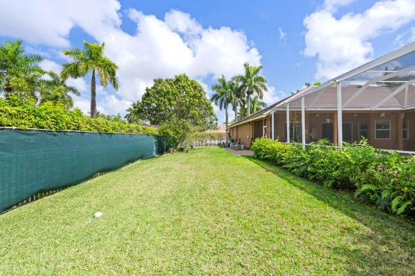 a view of a house with palm trees and a big yard