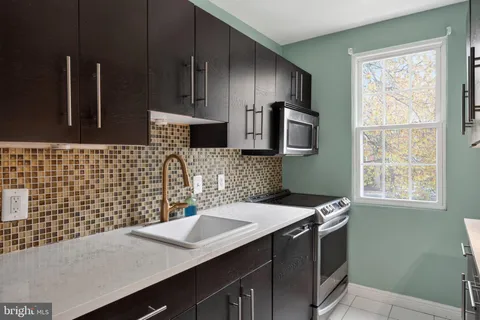a kitchen with a sink cabinets and window