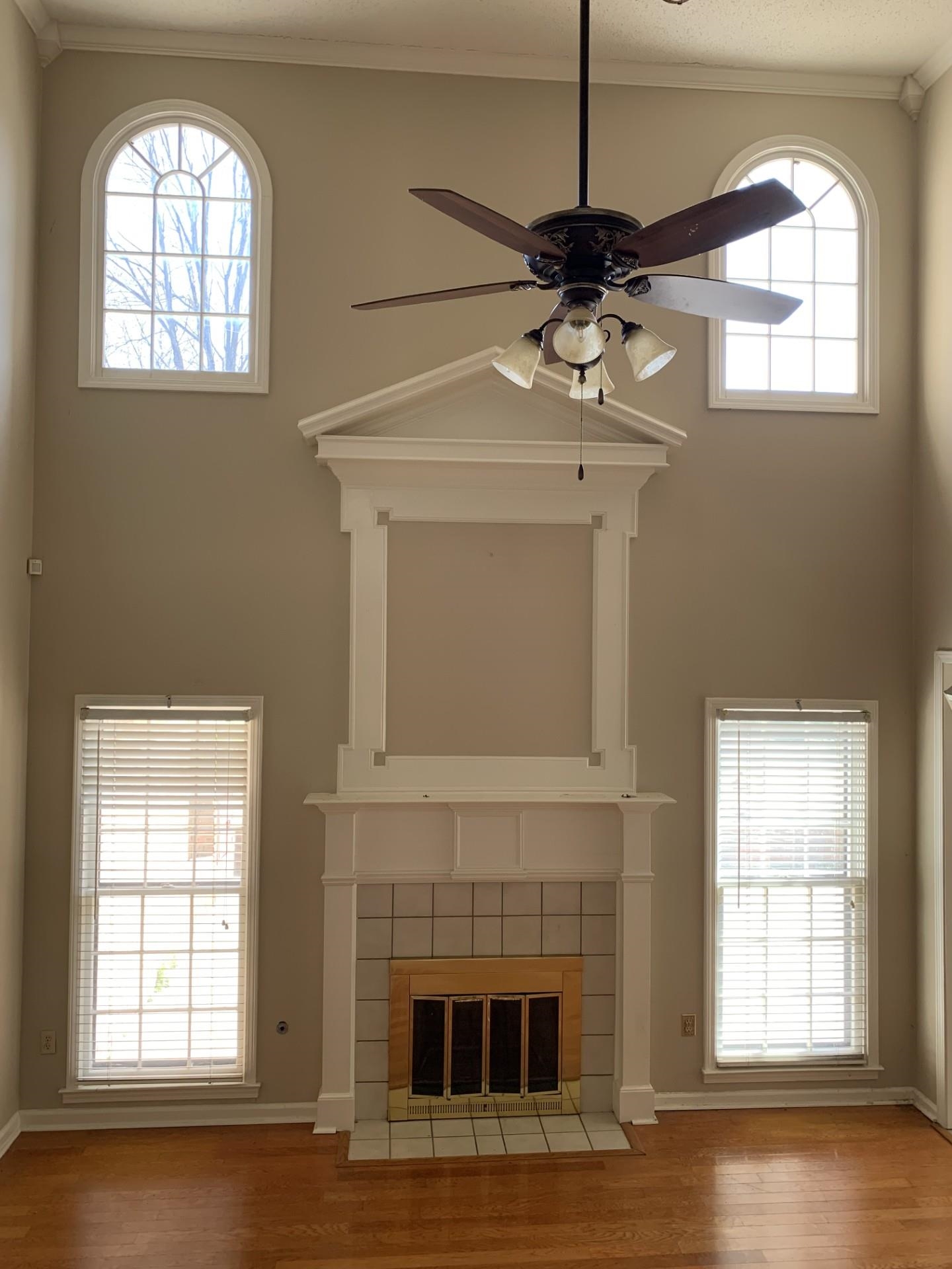 8717 Dexter Road Memphis, TN 38016 - Photo 3 of 12 Unfurnished living room featuring a wealth of natural light, crown molding, wood finished floors, and a ceiling fan.