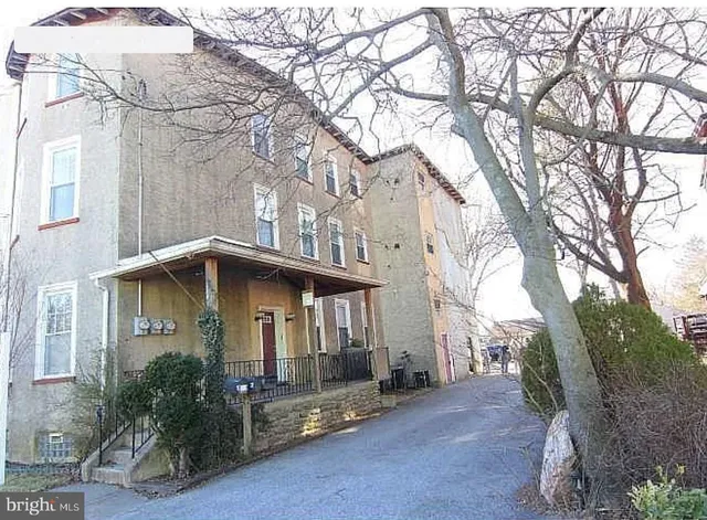 a yellow house with trees in front of it