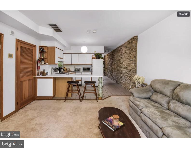 7928 Ridge Avenue Philadelphia, PA 19128 - Photo 12 of 38 a living room with stainless steel appliances kitchen island granite countertop furniture and a couch