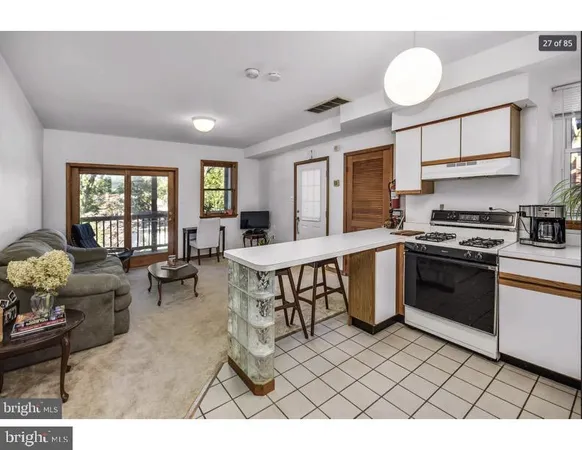 a open kitchen with stainless steel appliances granite countertop a stove a sink dishwasher a dining table and chairs with wooden floor